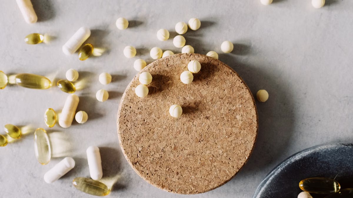 Assorted pills and capsules on a marble surface, highlighting healthcare and medicine.